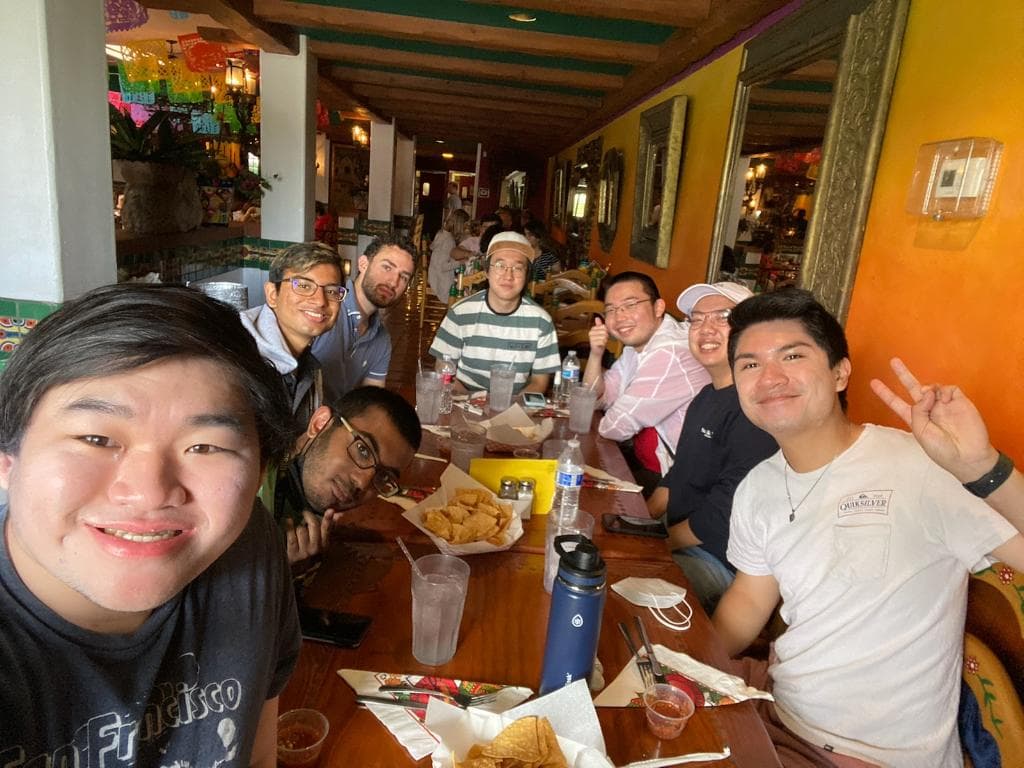 a bunch of people sitting and smiling at a table